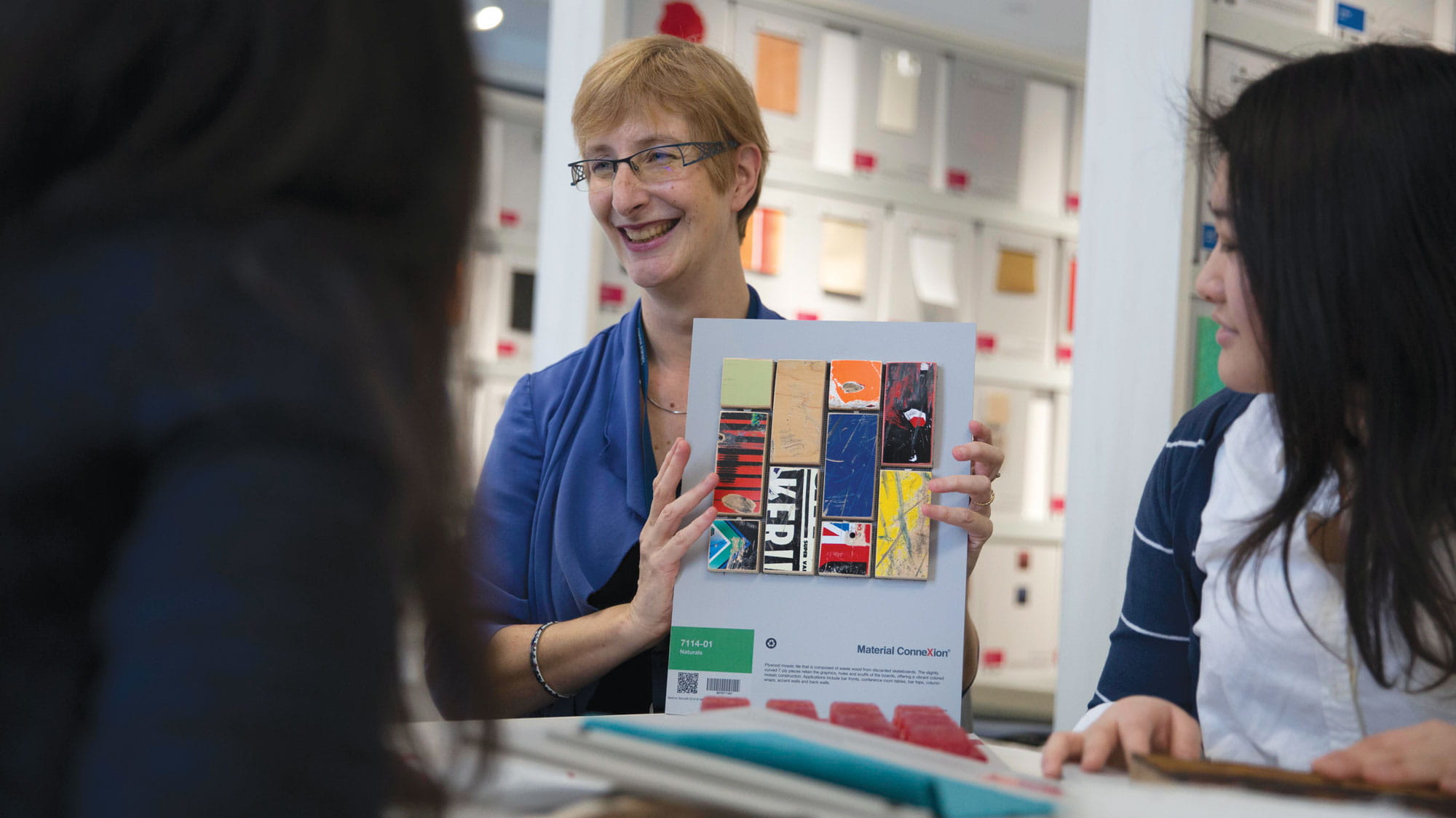 A Sheridan librarian shows two students a sample from the Material ConneXion Library.
