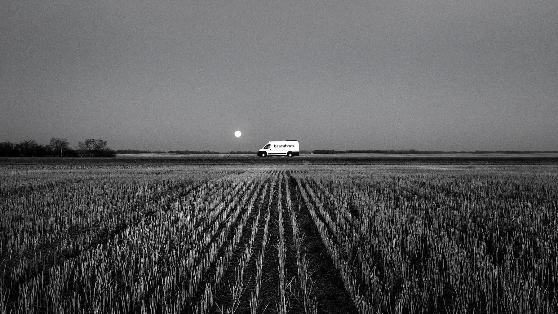 The Brandvan sitting on the road at the end of a long field.