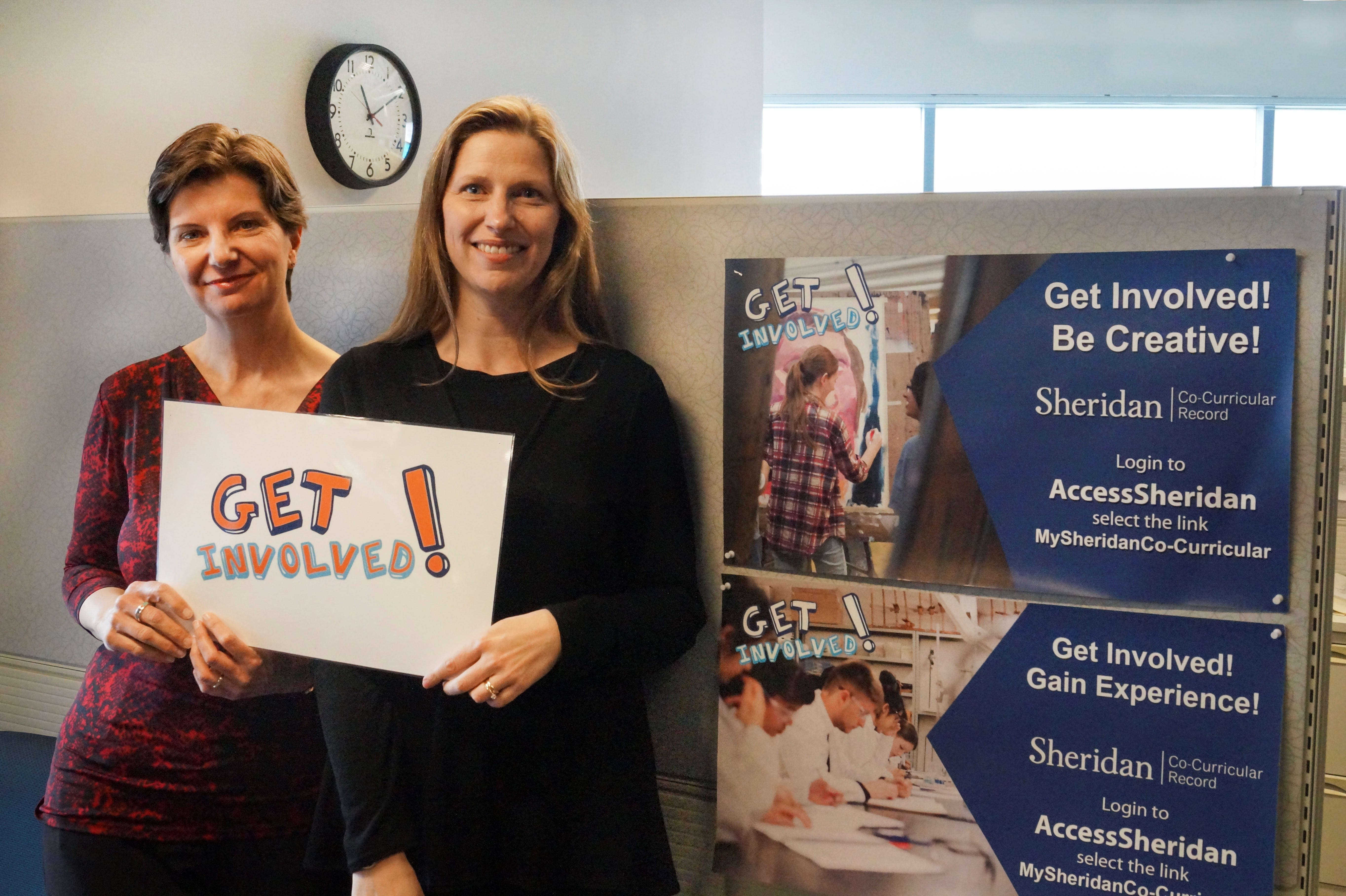 Co-Curricular Record team holding a sign that says 'Get Involved!'