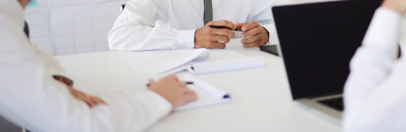 Students sitting around a table with laptops and papers