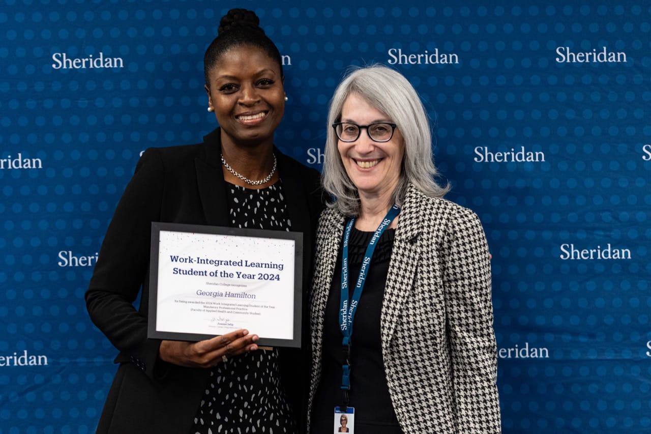Georgia Hamilton holds her certificate while standing next to Sheridan Director, Clinical and Experiential Learning Lisa Sokoloff