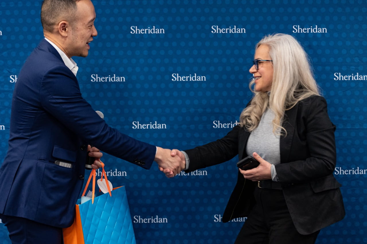 Sheridan Director, Industry and Professional Engagement Arthur Kong shakes hands with Unity Health's Eduarda Calado