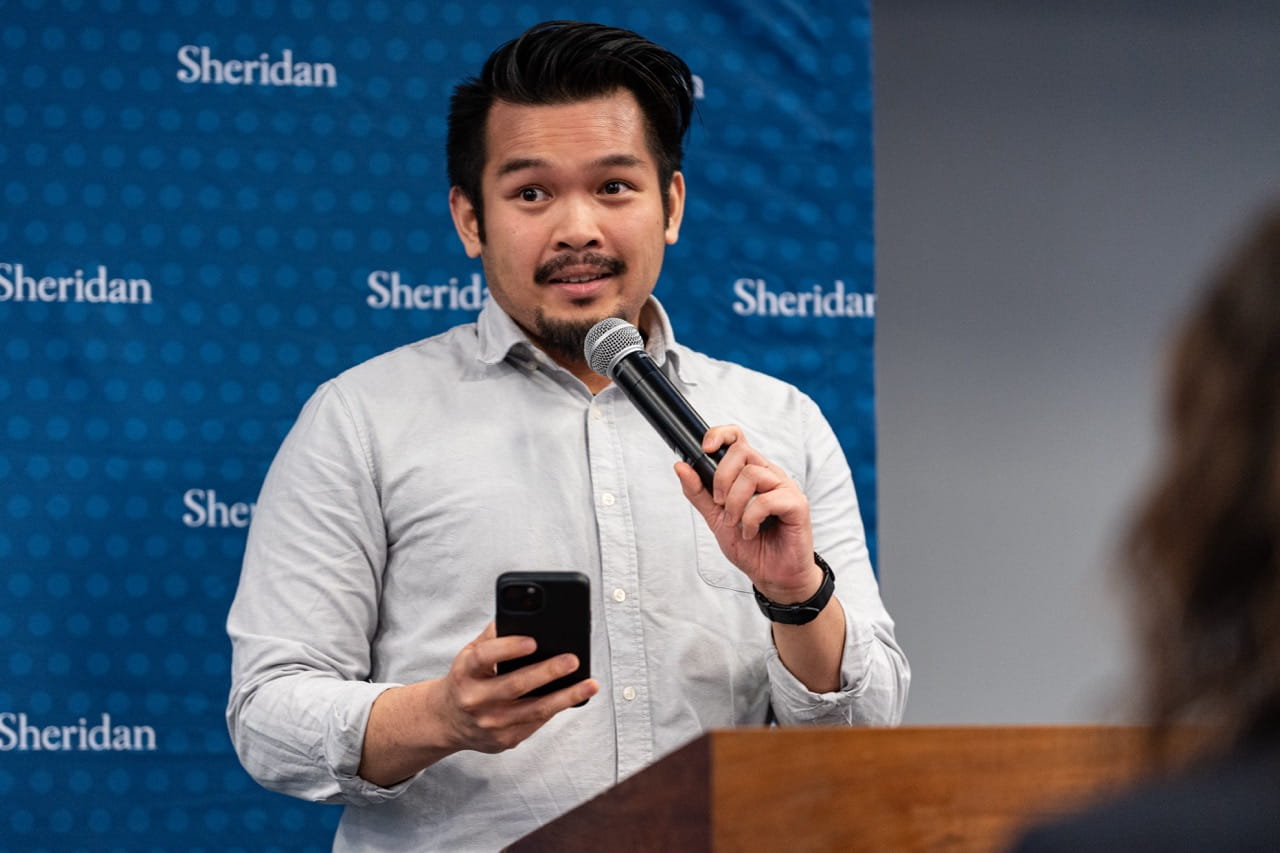 Daniel Ta speaks at the podium