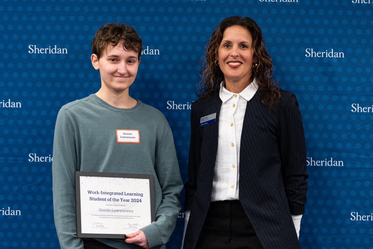 Quinlin Lawrynowicz holds his certificate while standing next to Sheridan Director, Career-Integrated Learning Joanne Islip