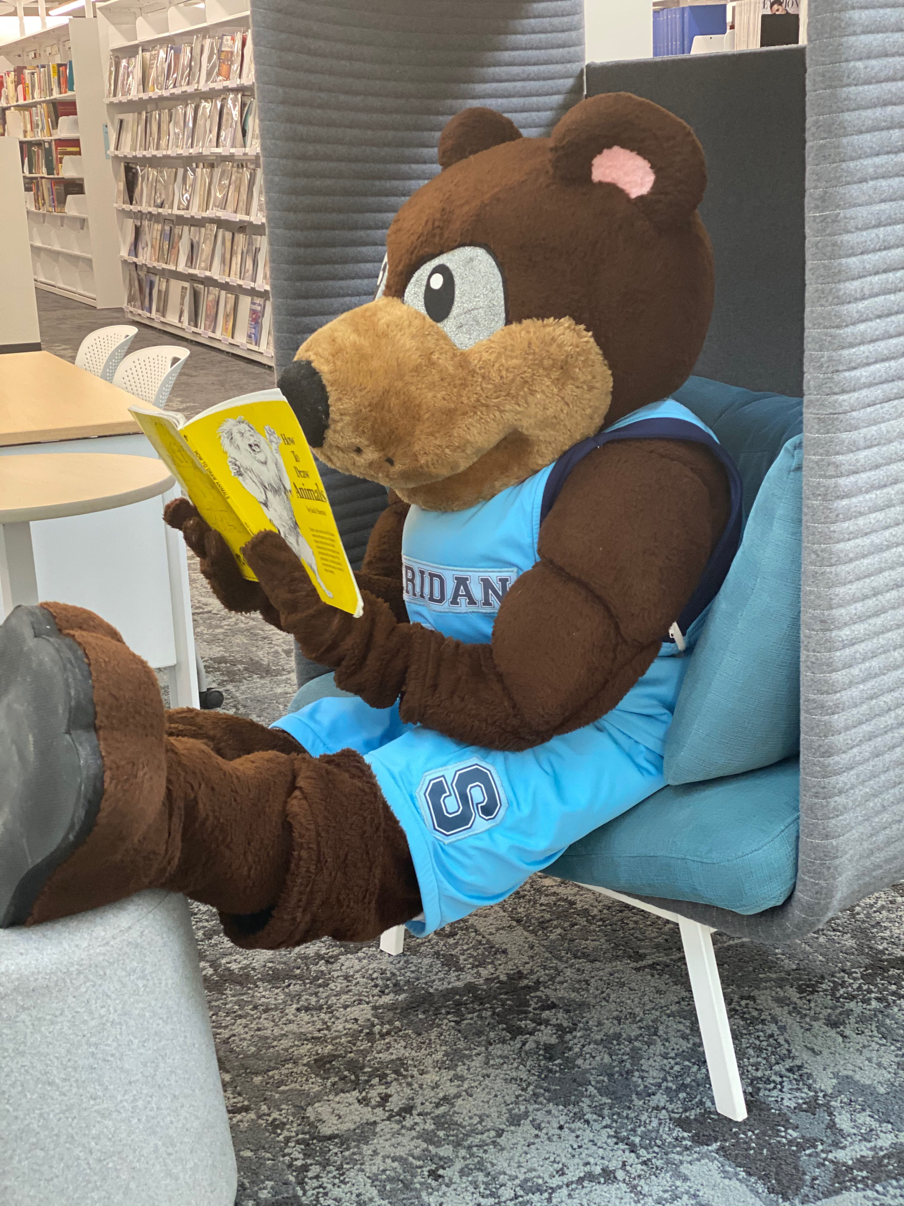 Bruno mascot reading a yellow book