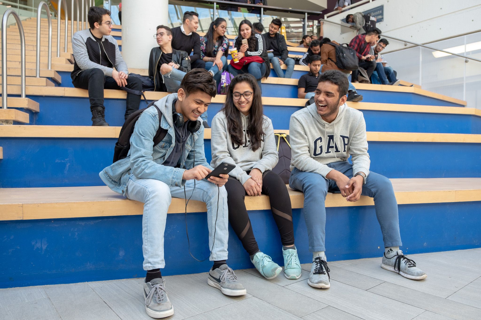 Students chatting while seated on benches.