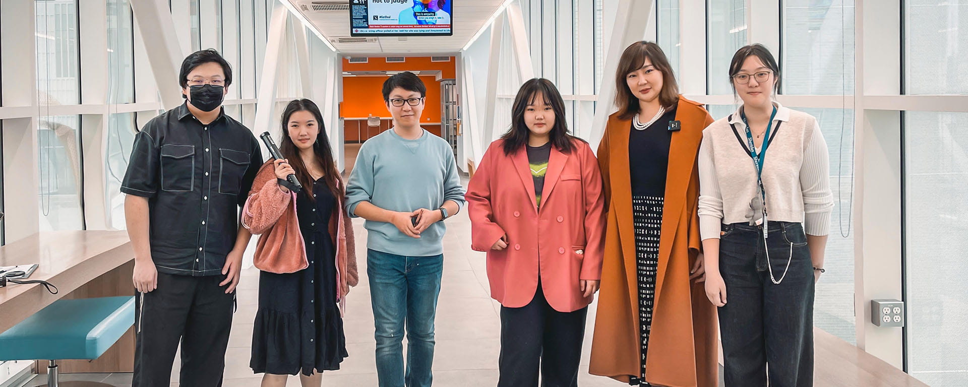 Students standing side-by-side in a hallway.