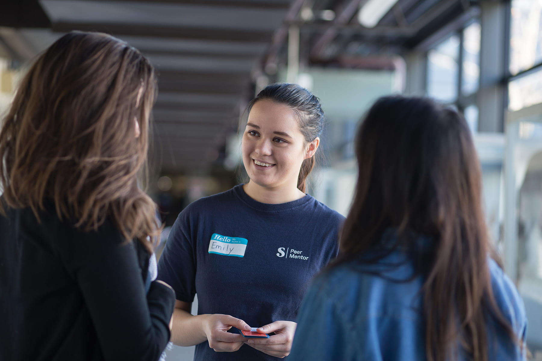 Peer mentor speaking to students on campus