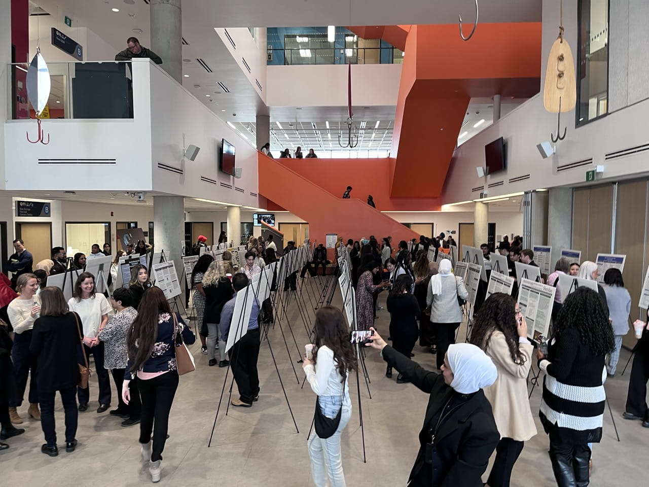 The Creativity Commons at Hazel McCallion Campus was filled with people viewing posters about degree students' capstone projects.