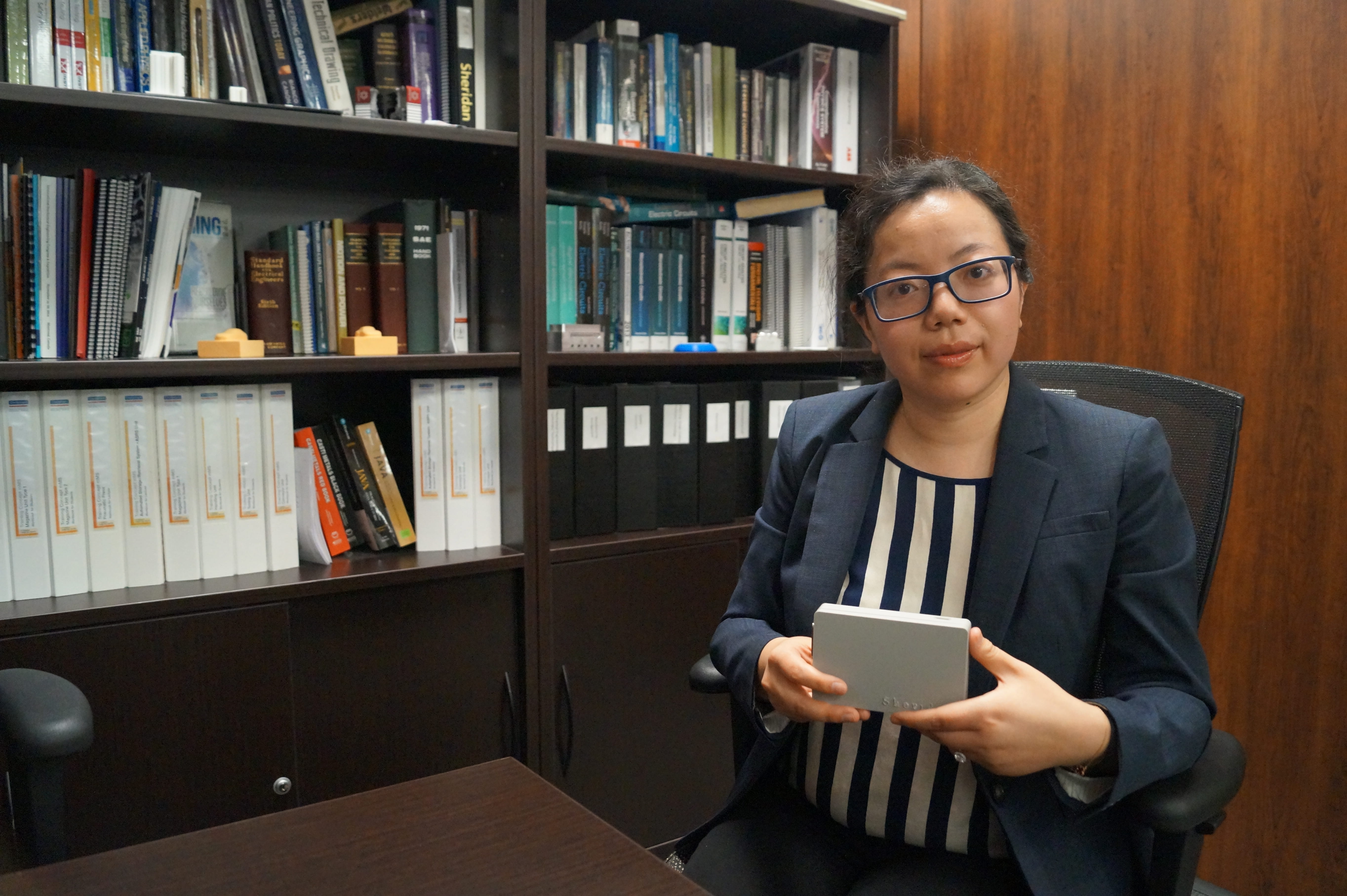Dr. Weijing Ma holding an EEG device