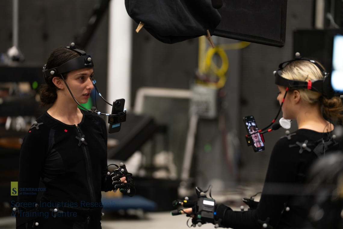 Two people wearing headsets facing each other in a darkened room