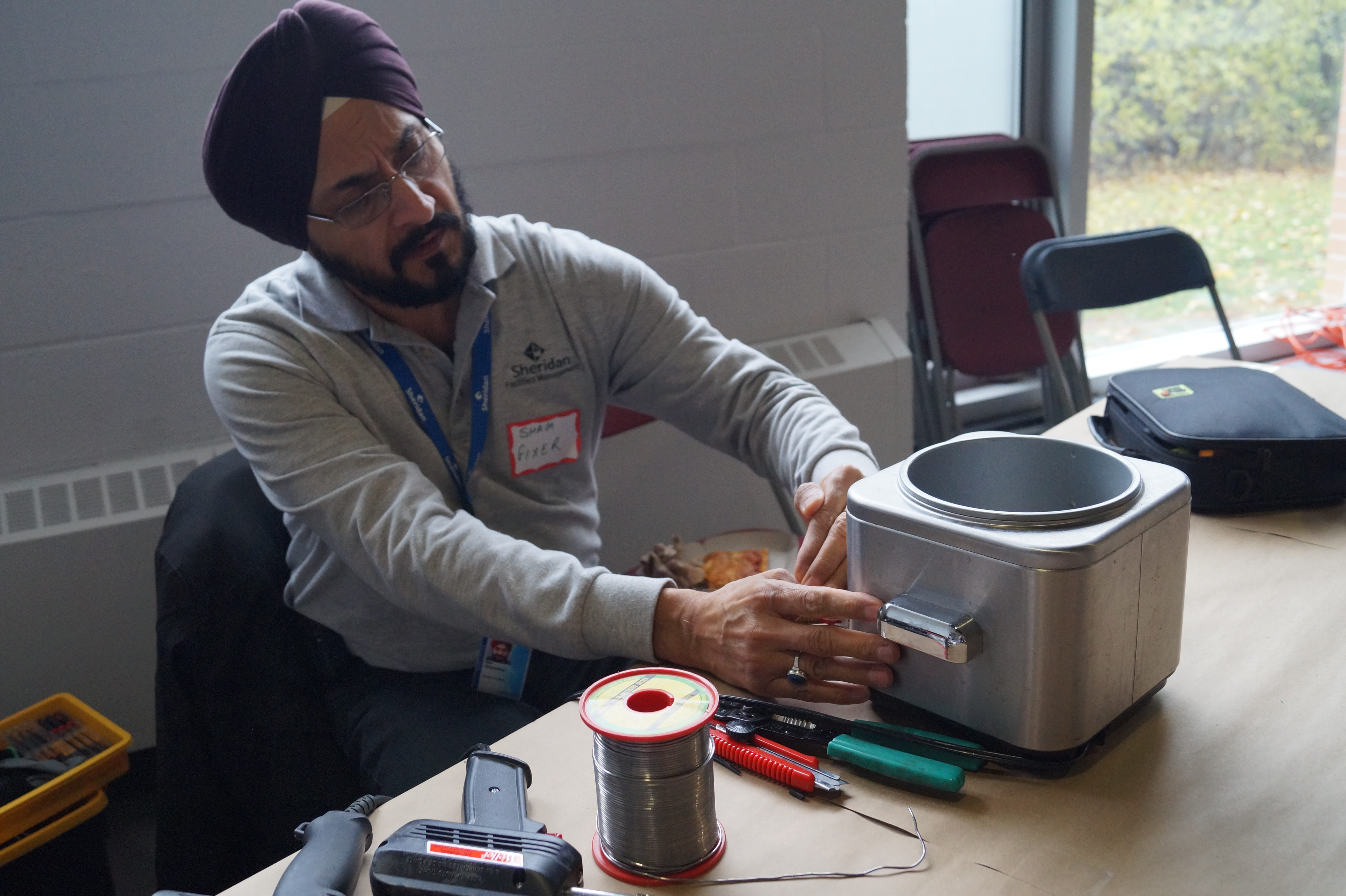 A volunteer Fixer working on an item at the Repair Cafe