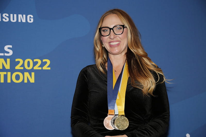 Sheridan Faculty of Applied Science & Technology Dean Lindsay Engel wears the three replica medals Sheridan received for hosting the WorldSkills Competition 2022 Special Edition Industrial Mechanics event.