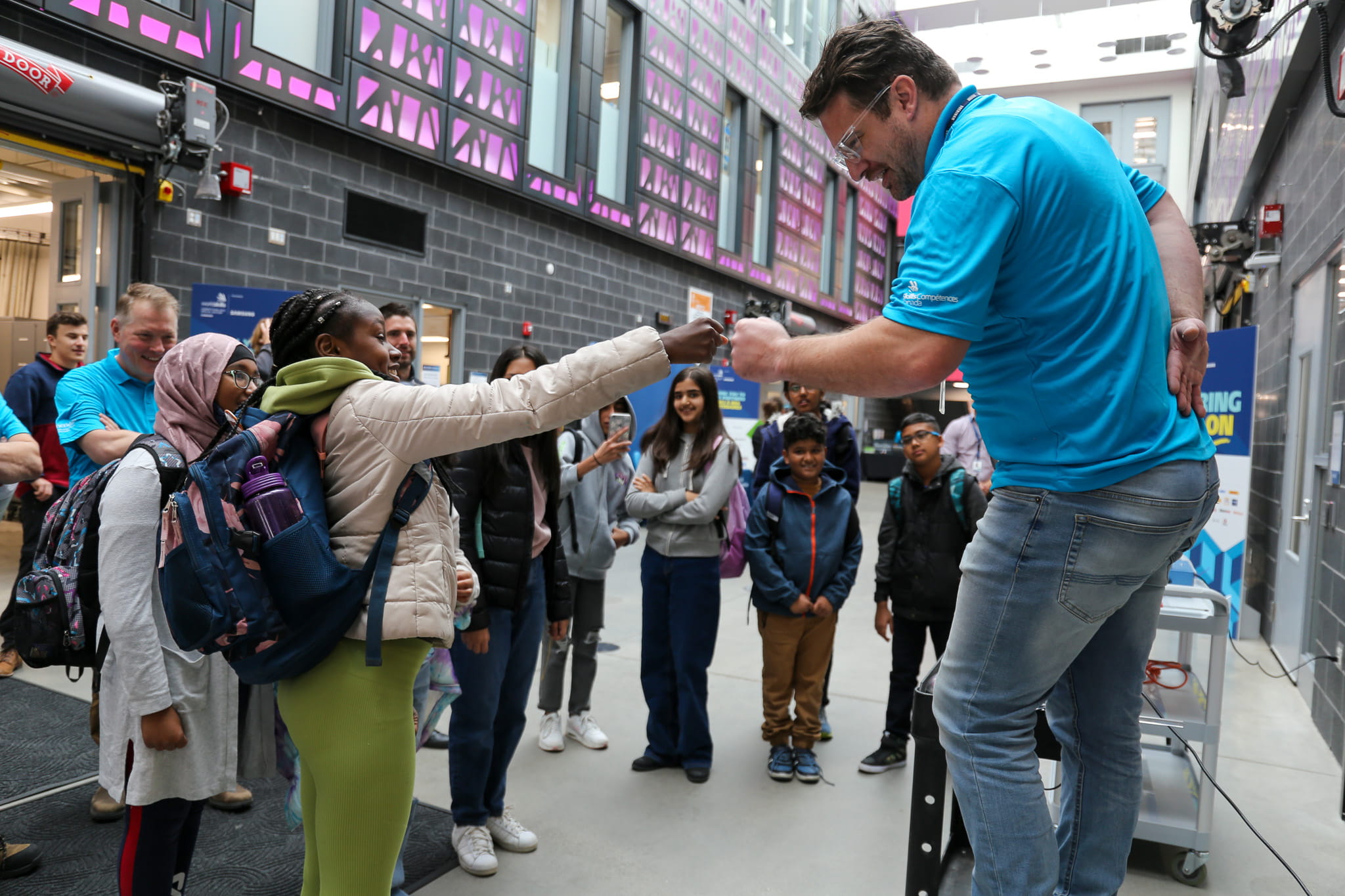 A student from Brampton's Fletcher's Creek Senior Public School interacts with a Sheridan employee during a tour of the Magna Skilled Trades Centre.