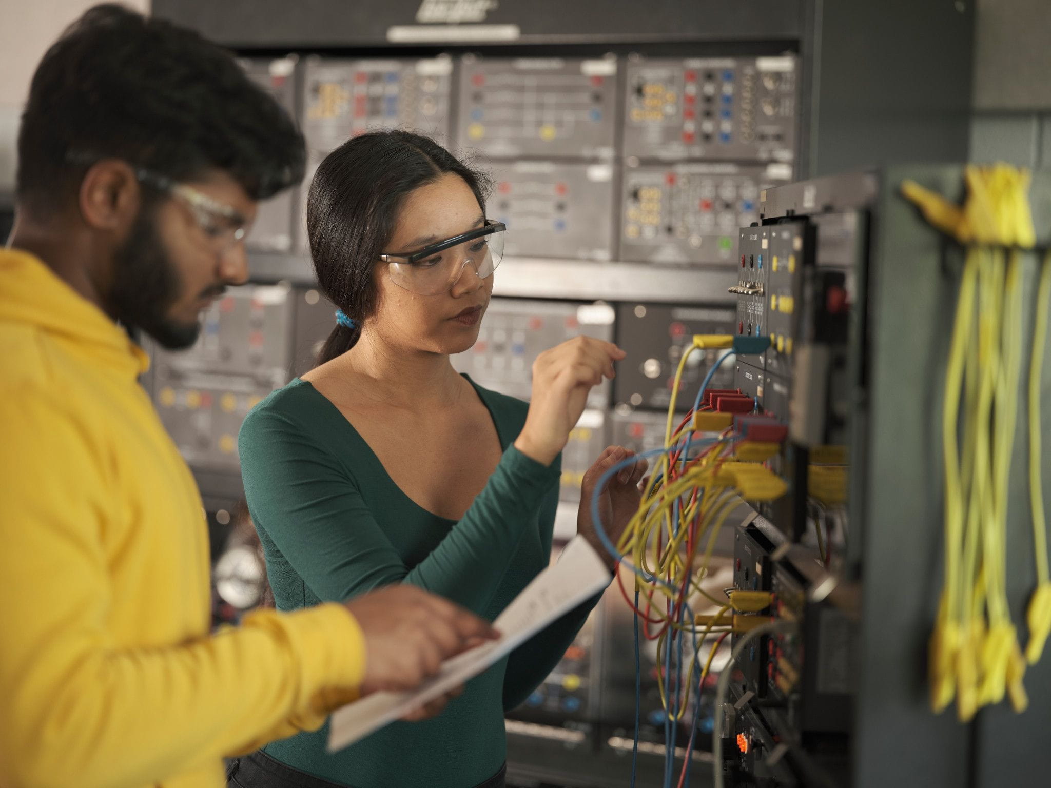 Two students work on a distribution panel in one of Sheridan's engineering labs
